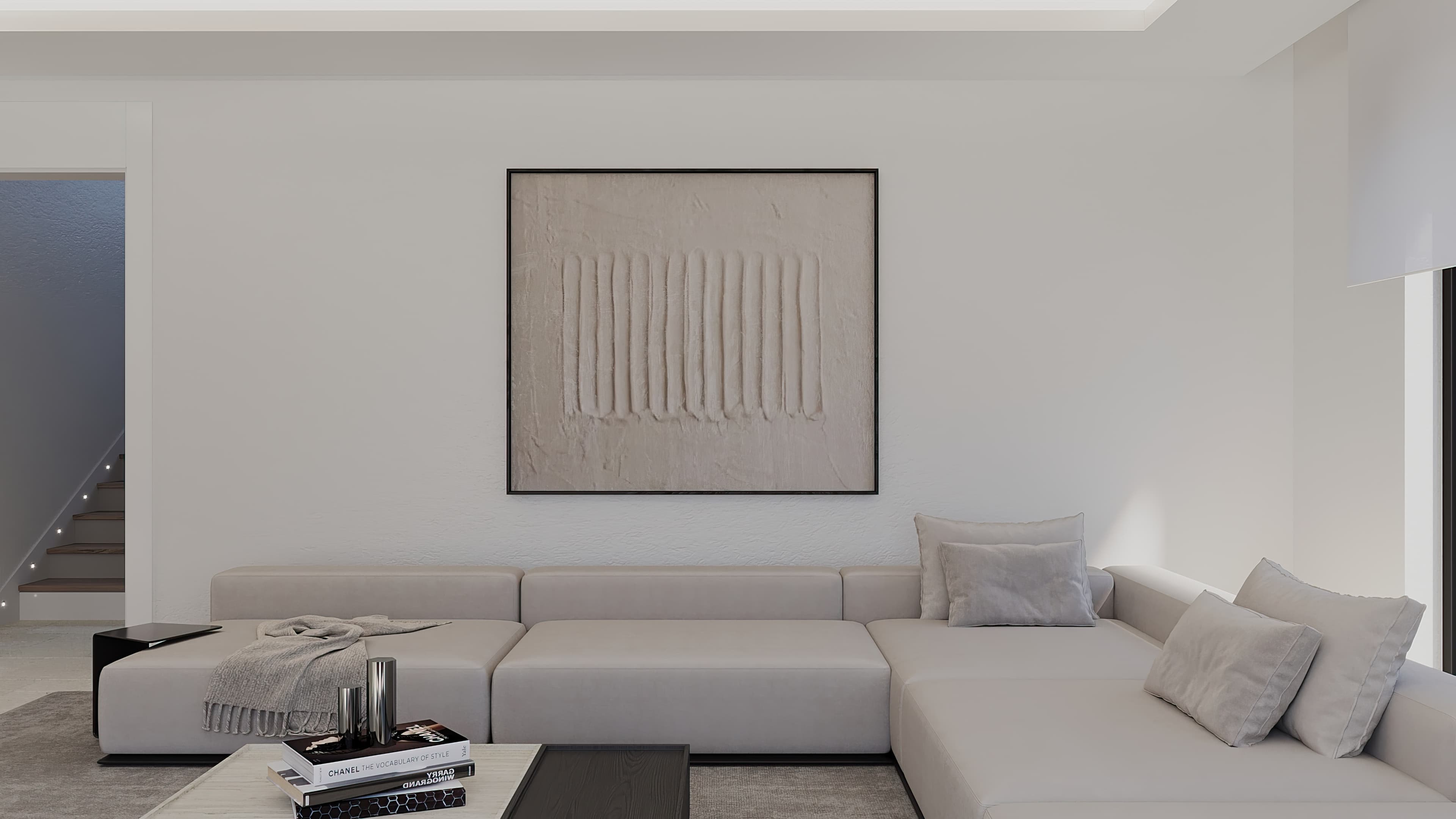 Living room sofa close-up with textured wall art and staircase beyond