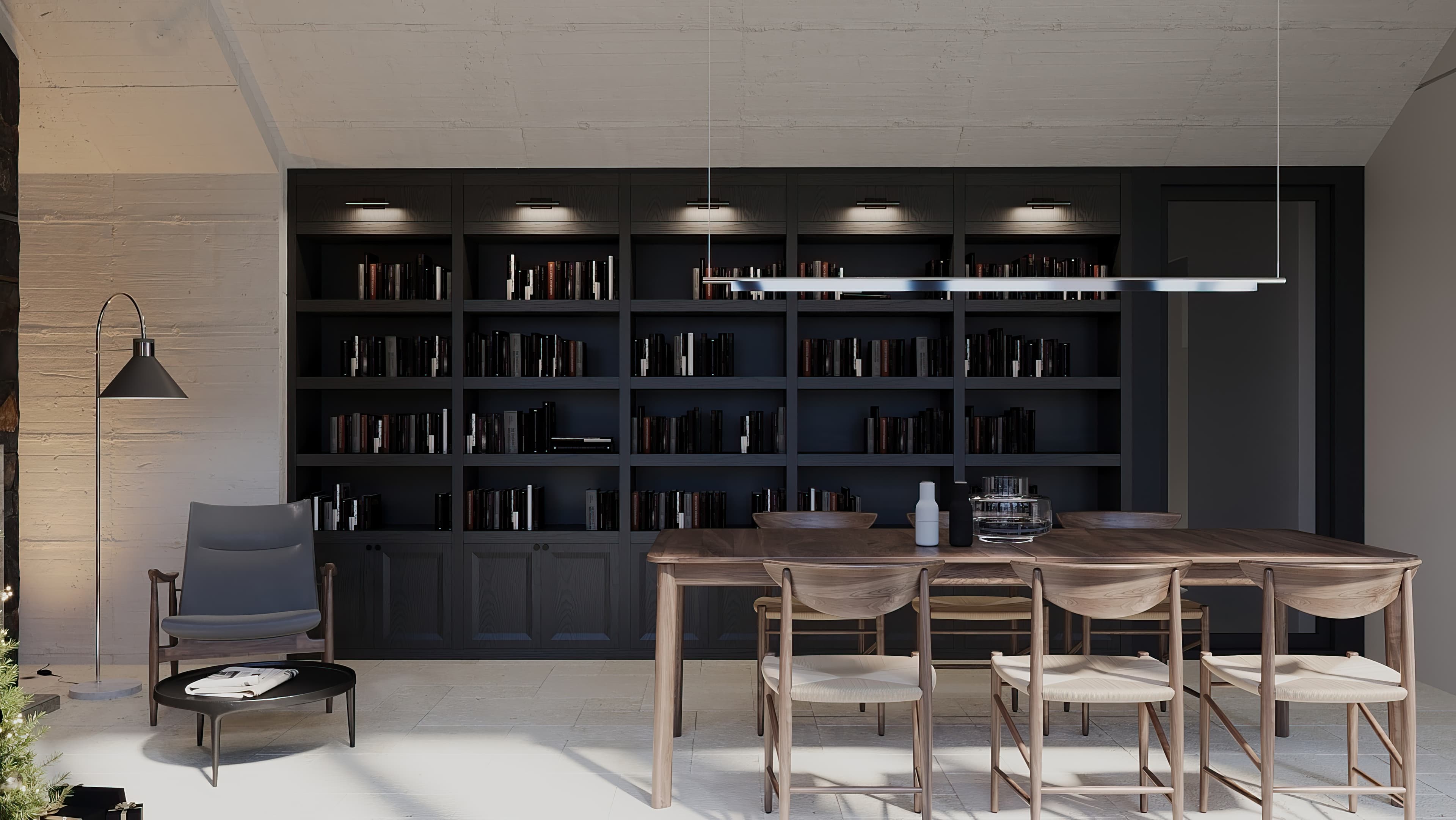 Library room with dark floor-to-ceiling bookshelf, walnut table, and armchair