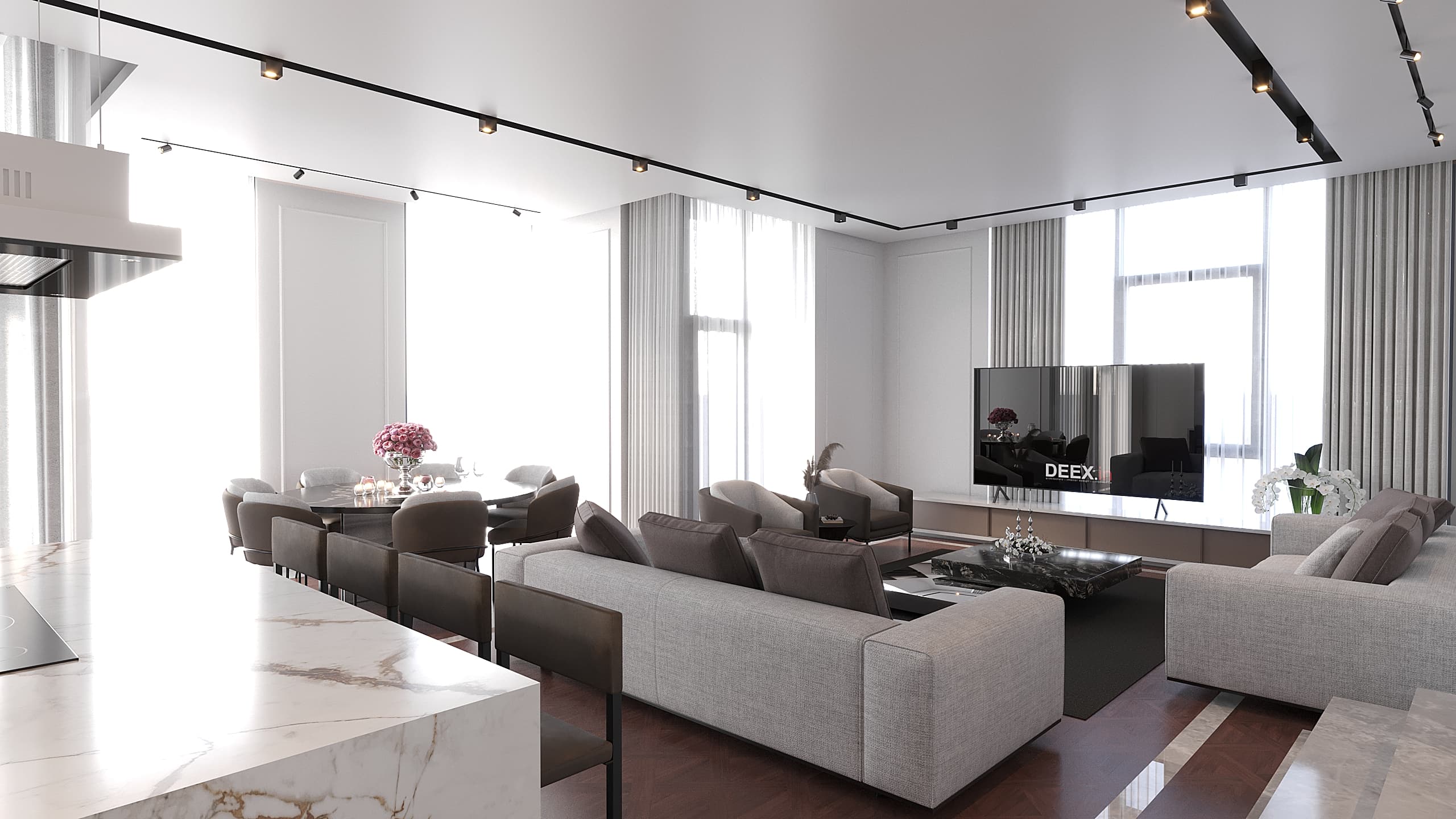 Wide living room with grey sofas, track lighting, TV wall, and kitchen island